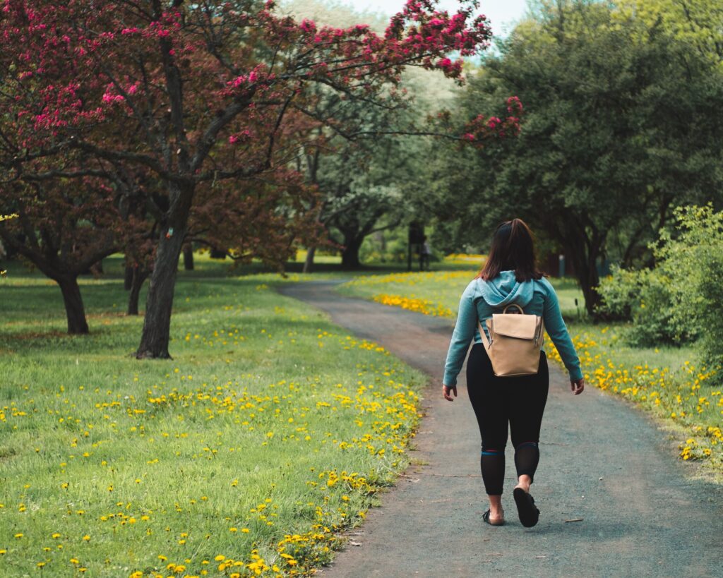 Woman walking away down Fall path