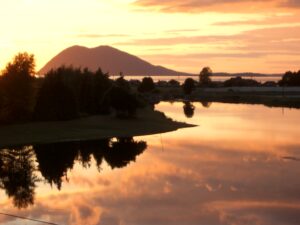 A view of the bright orange sunset on the water at samish island campground