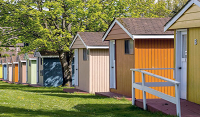 A row of colorfully painted small wooden cabins in the grass at samish camp.