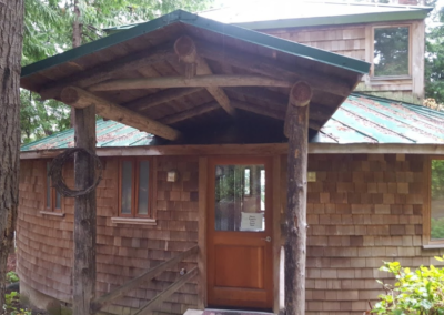The entrance to a brown-shingled yurt cabin at Indralaya Retreat center on Orcas Island, WA