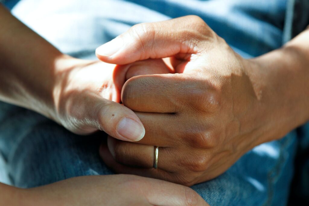 Two people holding left hands