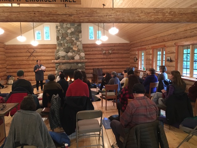 Group doing mindfulness training in a historic log structure.