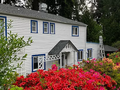 Lodging - Callison Home The exterior of a large meeting house made of pale wood at Whidbey Institute.